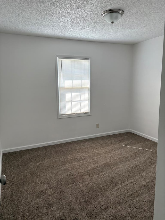 carpeted empty room with a textured ceiling