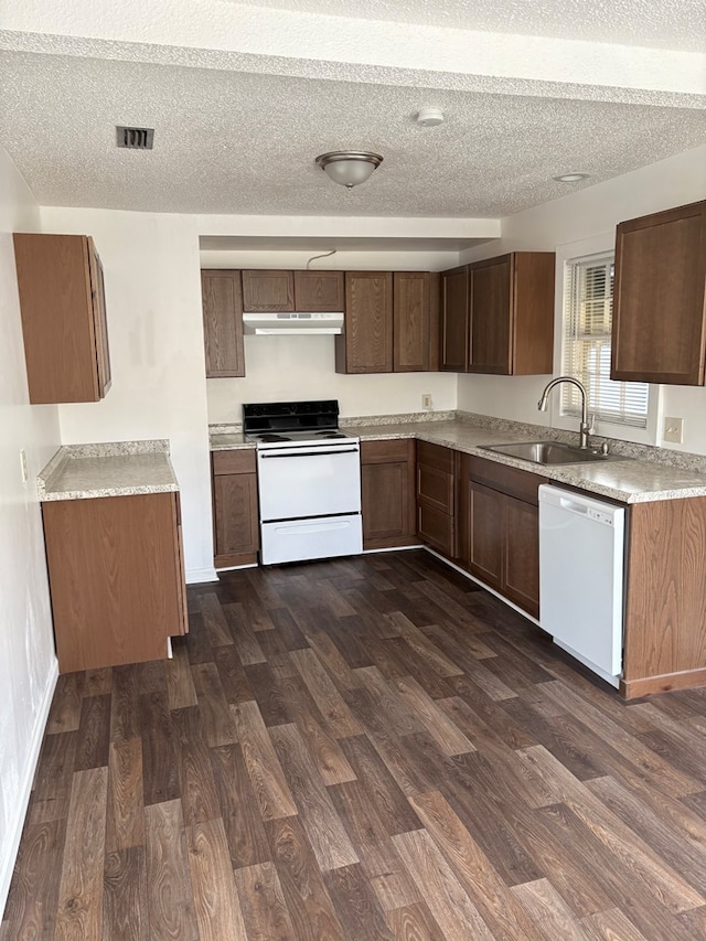 kitchen featuring a textured ceiling, sink, dark hardwood / wood-style floors, and white appliances