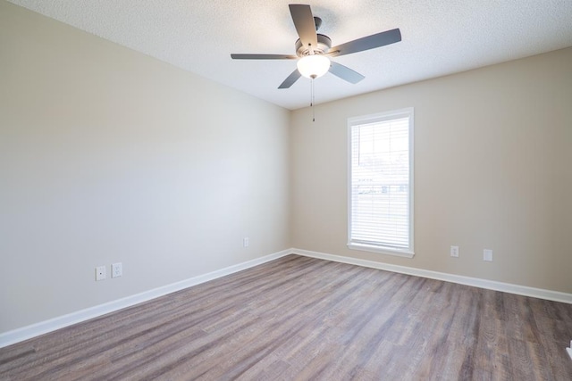 empty room featuring ceiling fan, a textured ceiling, baseboards, and wood finished floors