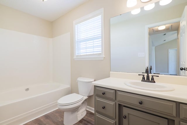 bathroom featuring bathing tub / shower combination, vanity, toilet, and wood finished floors