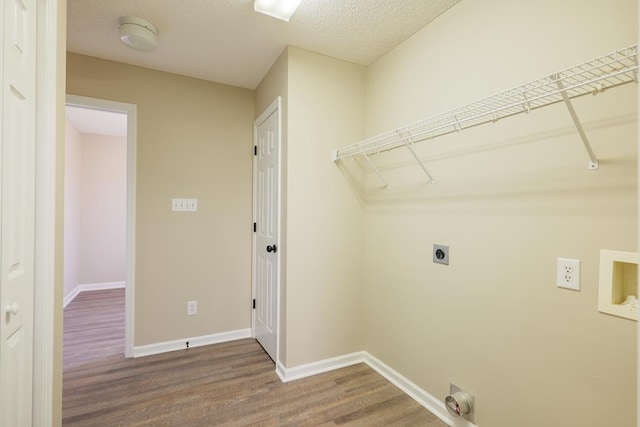 clothes washing area with laundry area, hookup for an electric dryer, baseboards, and wood finished floors