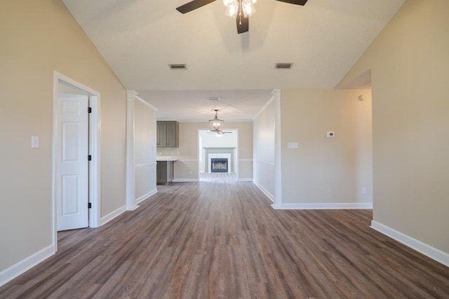 unfurnished living room featuring a fireplace with raised hearth, dark wood finished floors, and baseboards