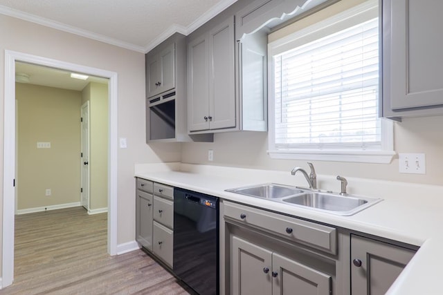 kitchen with a sink, light countertops, gray cabinets, dishwasher, and crown molding