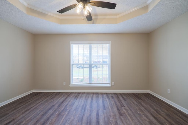 spare room featuring dark wood-style floors, a textured ceiling, a raised ceiling, and baseboards