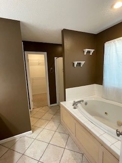 full bath with tile patterned floors, baseboards, a whirlpool tub, and a walk in closet