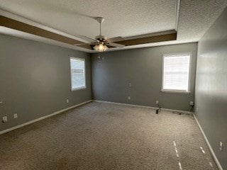 unfurnished room featuring carpet floors, a textured ceiling, ceiling fan, and baseboards