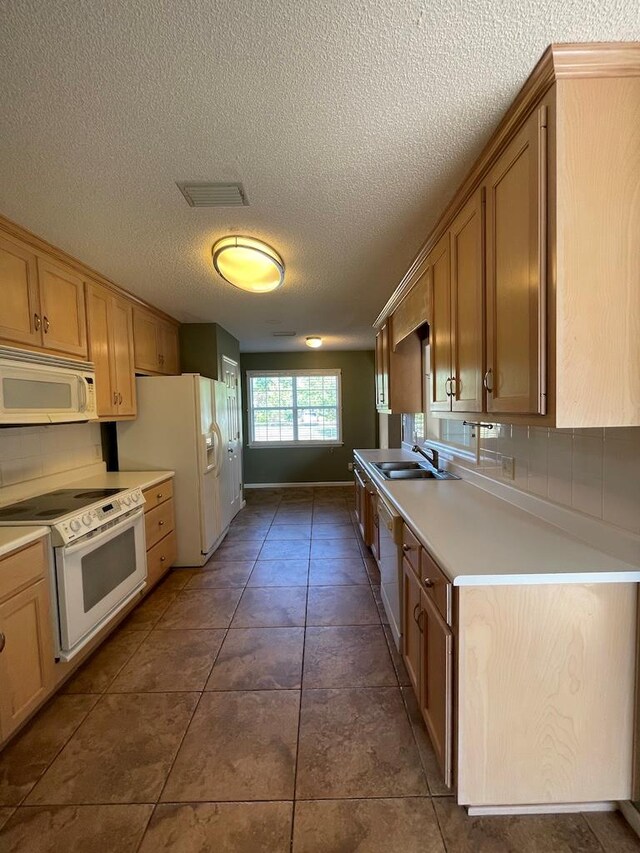 4331 Summerlin Dr, Valdosta, GA 31605 - kitchen with visible vents, white appliances, light countertops, a textured ceiling, and a sink