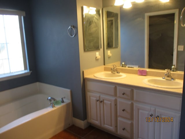 bathroom featuring a washtub, vanity, and tile patterned floors