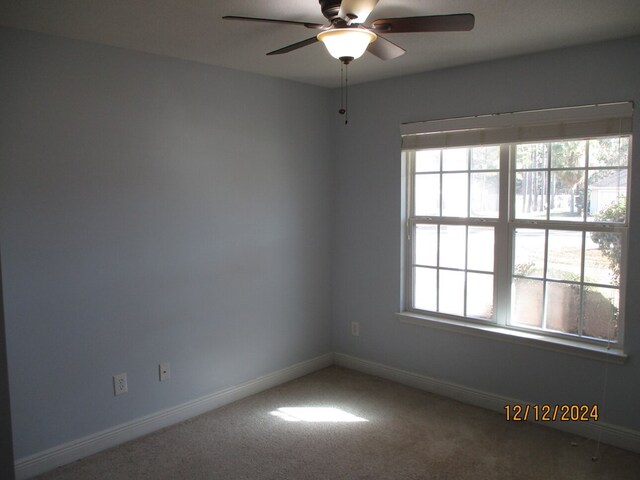 empty room with ceiling fan and carpet