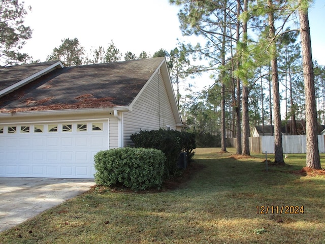 view of side of property with a yard and a garage