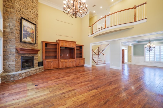 unfurnished living room featuring a high ceiling, hardwood / wood-style flooring, and a stone fireplace