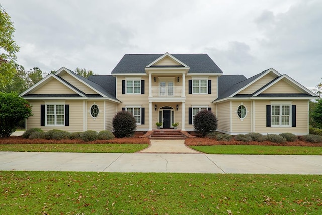 view of front of home featuring a balcony and a front yard