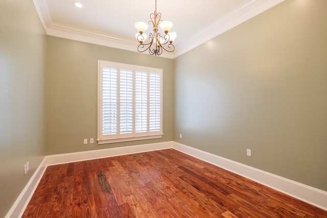 spare room with ornamental molding, a notable chandelier, and hardwood / wood-style flooring