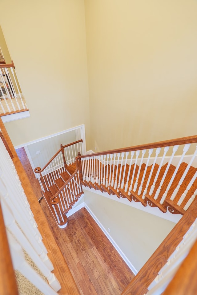 staircase with hardwood / wood-style floors