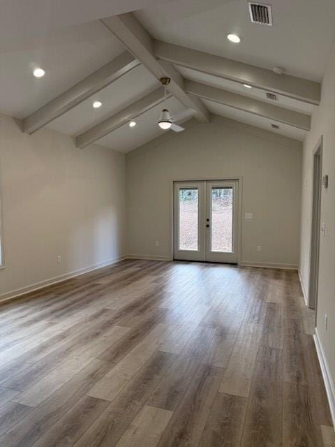 unfurnished room with hardwood / wood-style floors, lofted ceiling with beams, and french doors