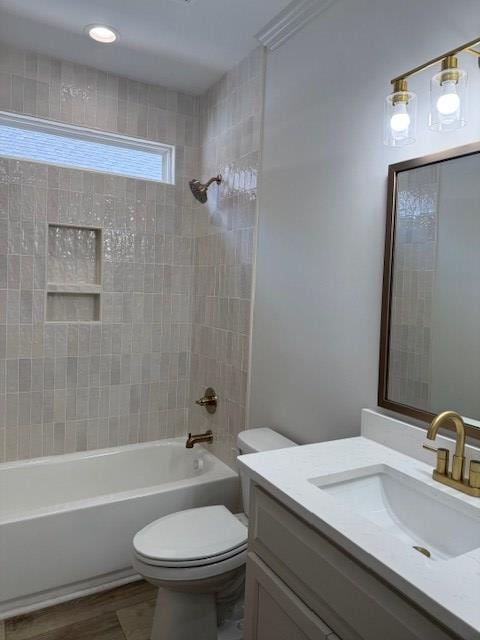 full bathroom with vanity, toilet, tiled shower / bath combo, and hardwood / wood-style floors