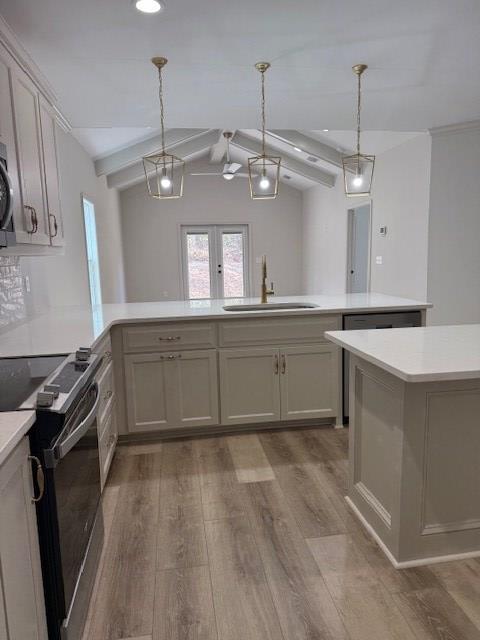 kitchen featuring sink, vaulted ceiling with beams, decorative light fixtures, electric range oven, and light wood-type flooring