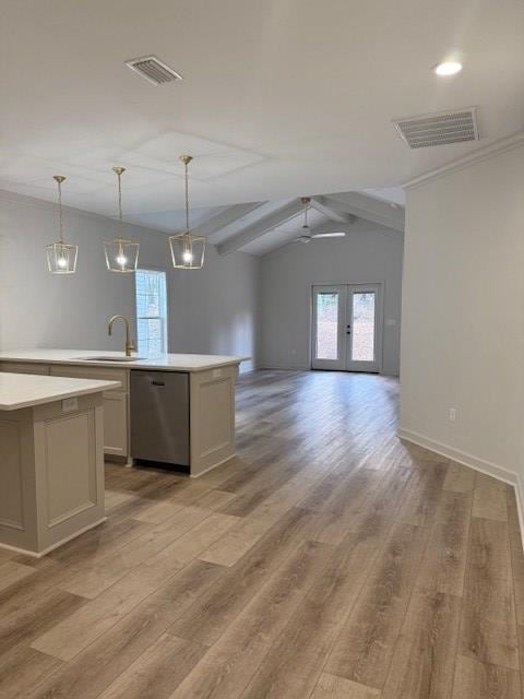 kitchen with hanging light fixtures, an island with sink, stainless steel dishwasher, and light wood-type flooring