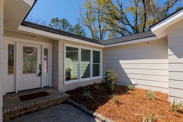 doorway to property with roof with shingles and crawl space