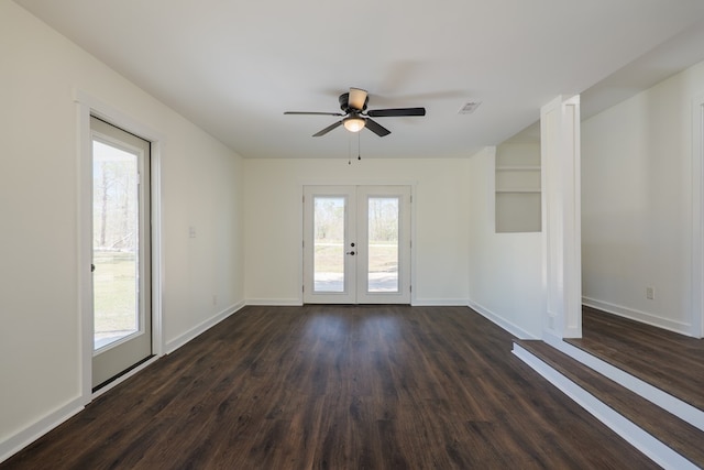 empty room featuring french doors, visible vents, dark wood finished floors, and baseboards