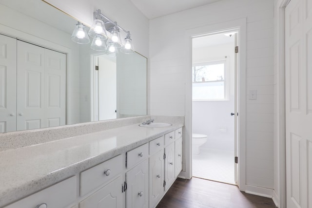 bathroom with toilet, wood finished floors, and vanity