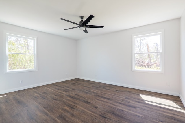 spare room featuring dark wood-type flooring, baseboards, and a ceiling fan