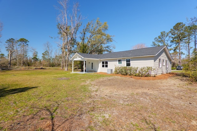 back of property with driveway, a patio area, central AC, and a lawn