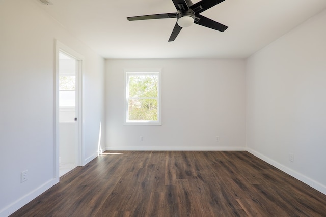 empty room with dark wood-type flooring, baseboards, and a ceiling fan