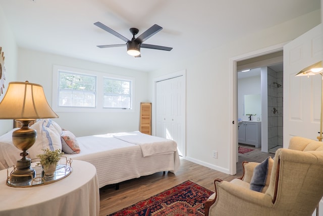 bedroom featuring ceiling fan, sink, wood-type flooring, and a closet