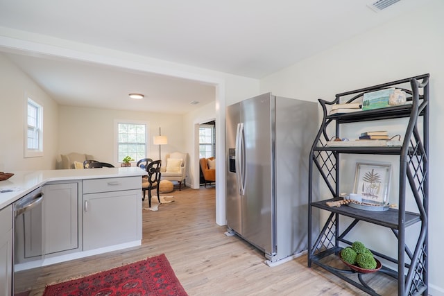 kitchen featuring appliances with stainless steel finishes, gray cabinetry, and light hardwood / wood-style flooring