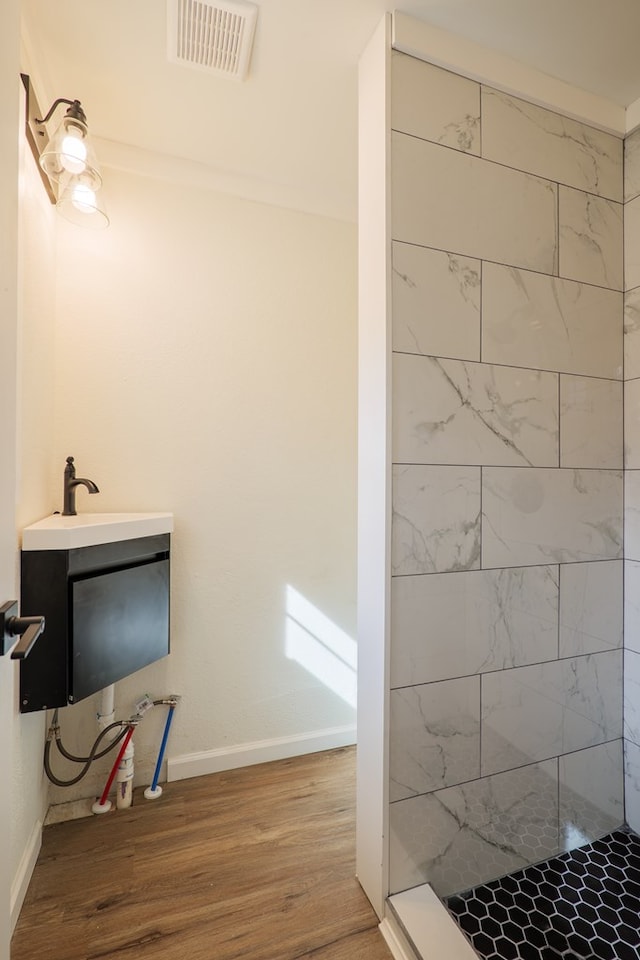 bathroom with walk in shower, sink, and hardwood / wood-style flooring