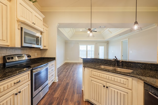 3982 Karaline Cir, Valdosta, GA 31605 - kitchen featuring appliances with stainless steel finishes, cream cabinets, dark wood-style floors, crown molding, and dark stone counters