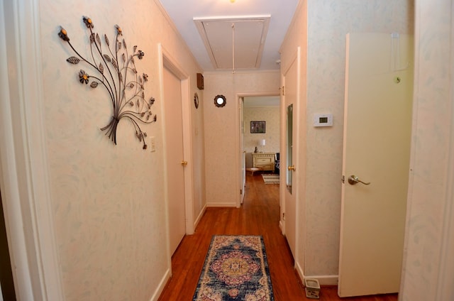 hall with attic access, wood finished floors, and baseboards