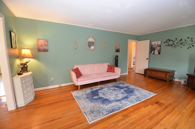 living area featuring crown molding, wood finished floors, and baseboards