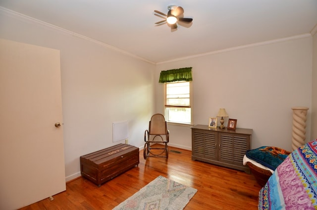 bedroom with visible vents, ornamental molding, wood finished floors, baseboards, and ceiling fan