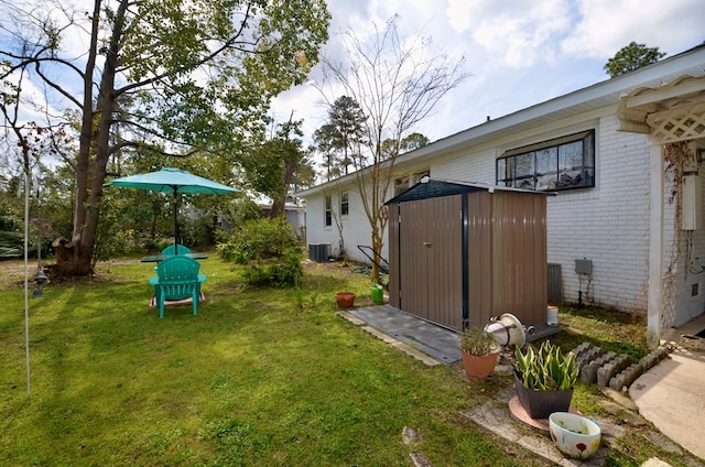 view of yard featuring central AC unit, an outdoor structure, and a shed