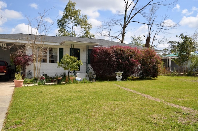 view of front of home featuring a carport, brick siding, concrete driveway, and a front yard