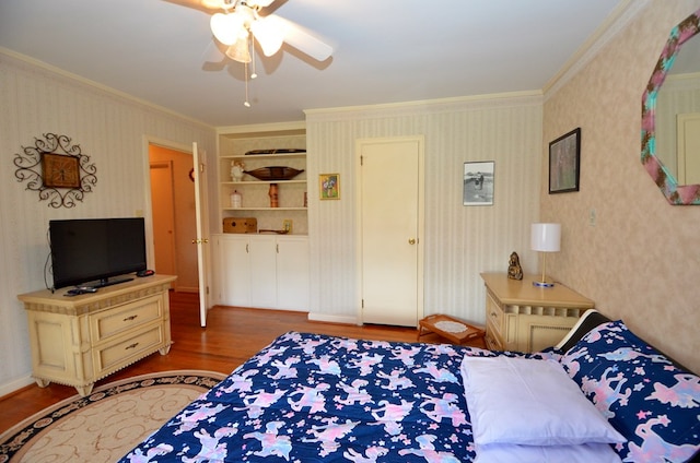 bedroom with light wood-type flooring, ornamental molding, a ceiling fan, and wallpapered walls