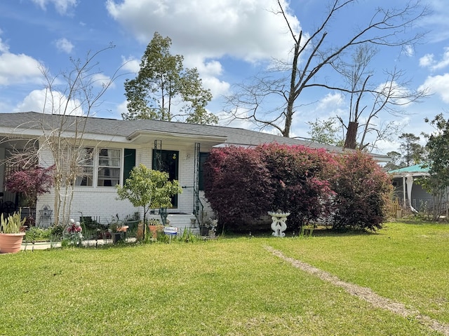 view of front facade featuring brick siding and a front lawn