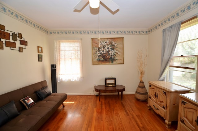 living area with a ceiling fan, light wood-style floors, and baseboards