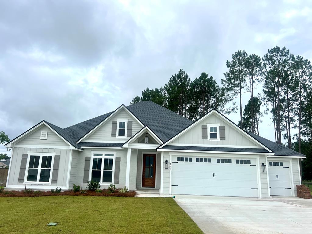 5008 Hatfield Cir, Hahira, GA 31632 - view of front facade featuring board and batten siding, an attached garage, concrete driveway, and a shingled roof