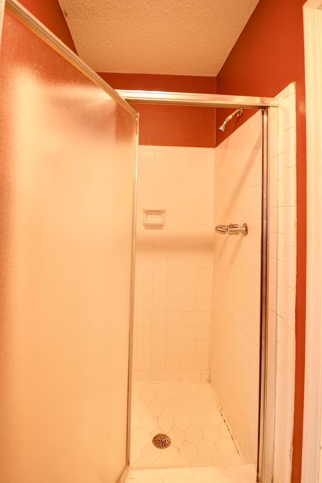 bathroom with an enclosed shower and a textured ceiling