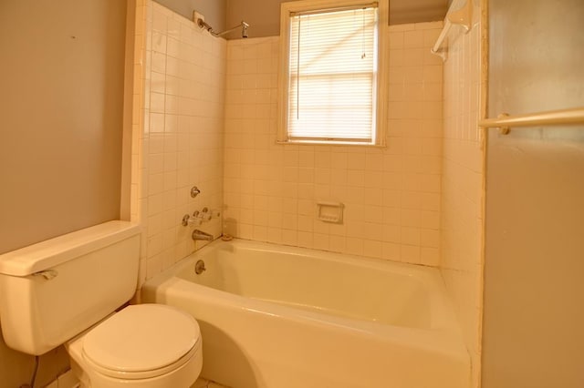 bathroom featuring tiled shower / bath combo and toilet