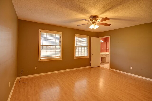 spare room with ceiling fan, light hardwood / wood-style floors, and a textured ceiling