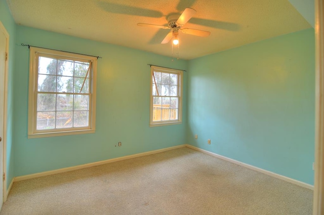 empty room featuring carpet, ceiling fan, and a healthy amount of sunlight