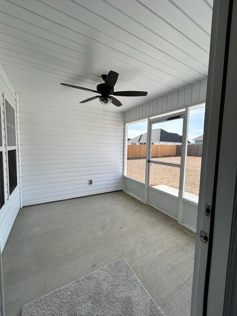 unfurnished sunroom with ceiling fan