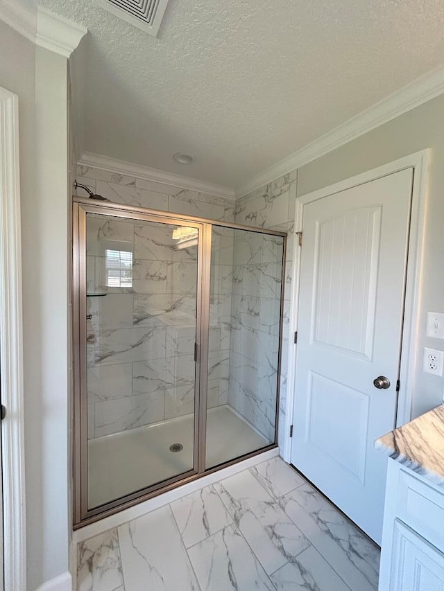 bathroom with vanity, ornamental molding, a textured ceiling, and walk in shower