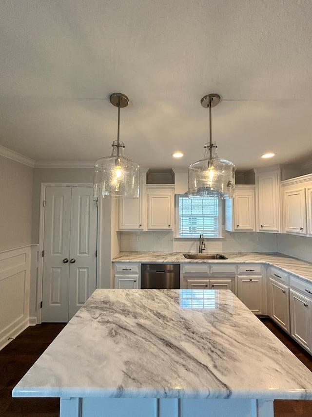 kitchen with sink, a center island, stainless steel dishwasher, and decorative light fixtures