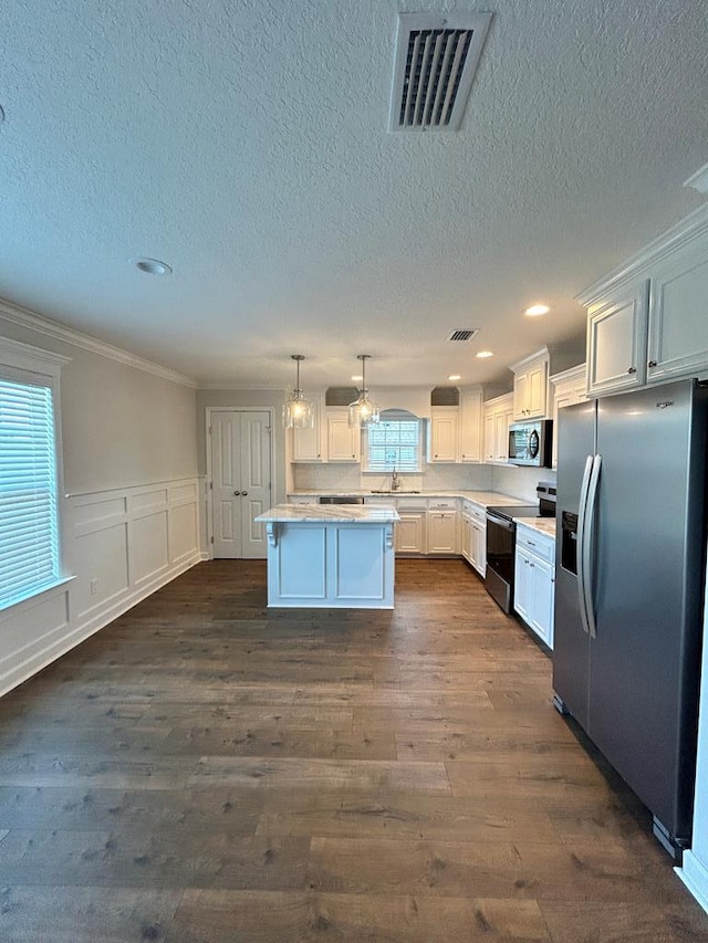 kitchen with white cabinetry, a kitchen island, stainless steel appliances, and dark hardwood / wood-style floors