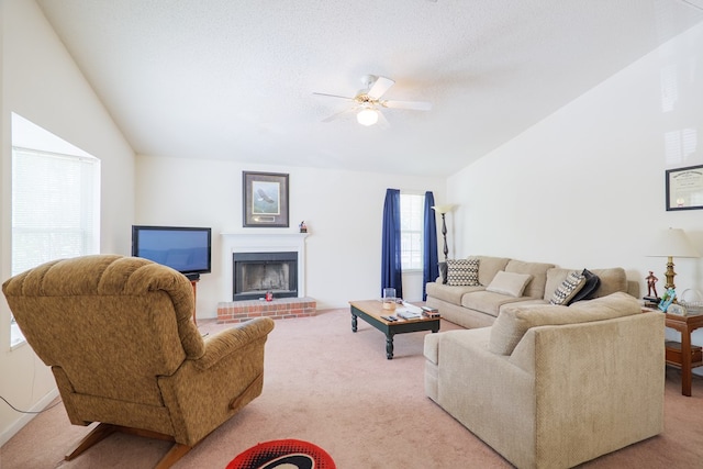 carpeted living area with ceiling fan, a fireplace, and vaulted ceiling